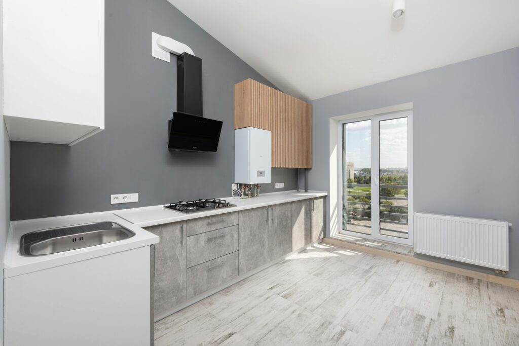 Sleek and modern kitchen with minimalist design, light colors, and large windows.